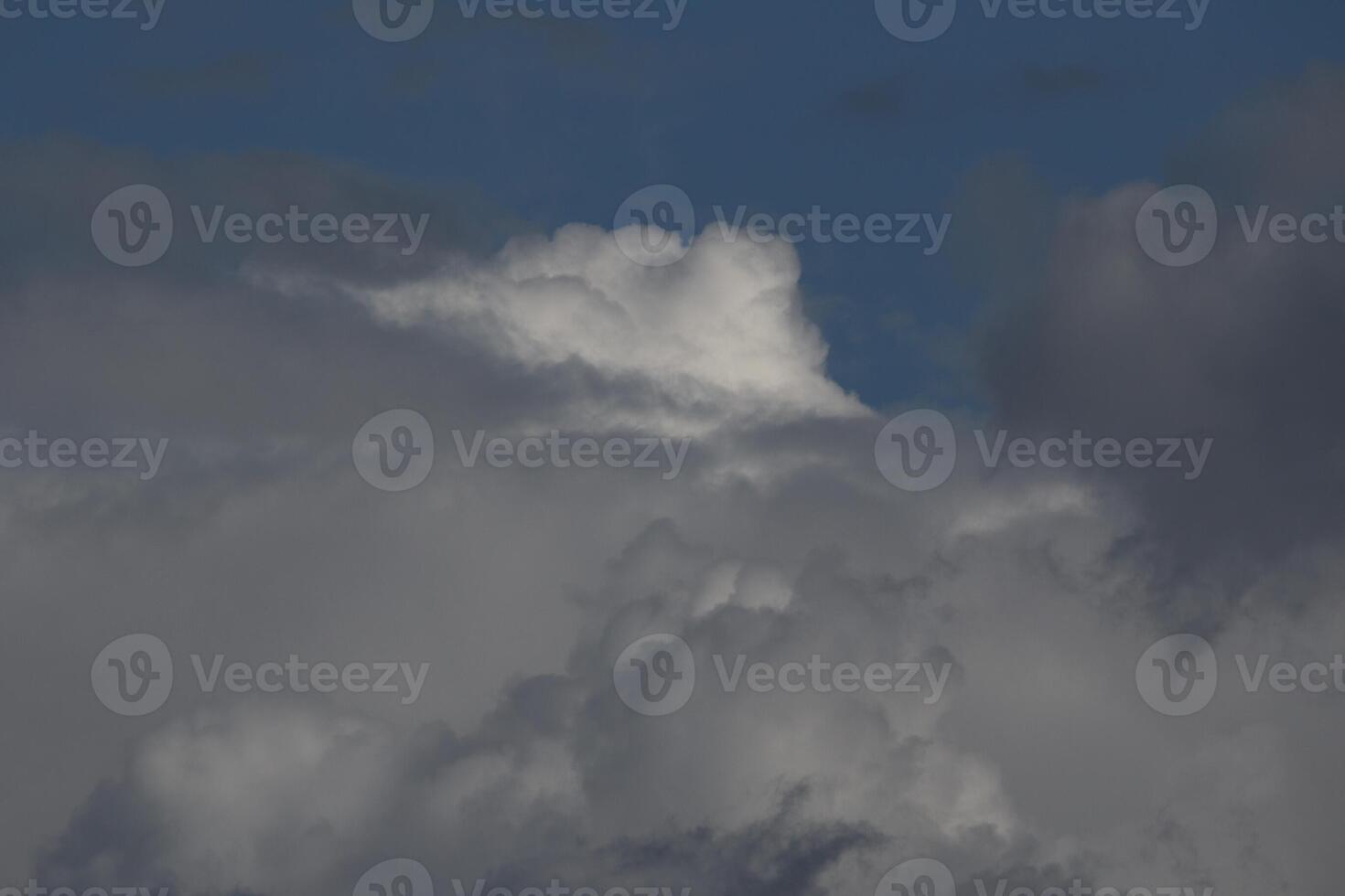 Cloudscape scenery, overcast weather above dark blue sky. Storm clouds floating in a rainy dull day with natural light. White and grey scenic environment background. Nature view. photo
