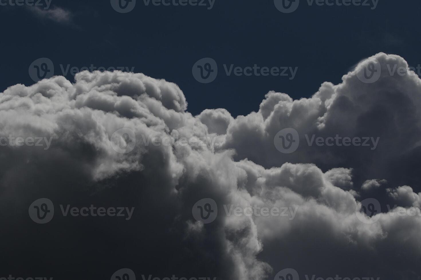 Cloudscape scenery, overcast weather above dark blue sky. Storm clouds floating in a rainy dull day with natural light. White and grey scenic environment background. Nature view. photo