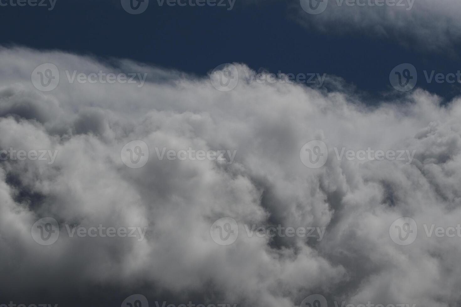 Cloudscape scenery, overcast weather above dark blue sky. Storm clouds floating in a rainy dull day with natural light. White and grey scenic environment background. Nature view. photo