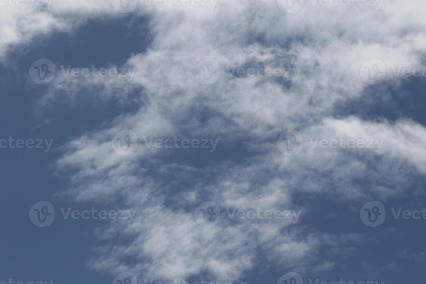 Cloudscape scenery, overcast weather above dark blue sky. Storm clouds floating in a rainy dull day with natural light. White and grey scenic environment background. Nature view. photo
