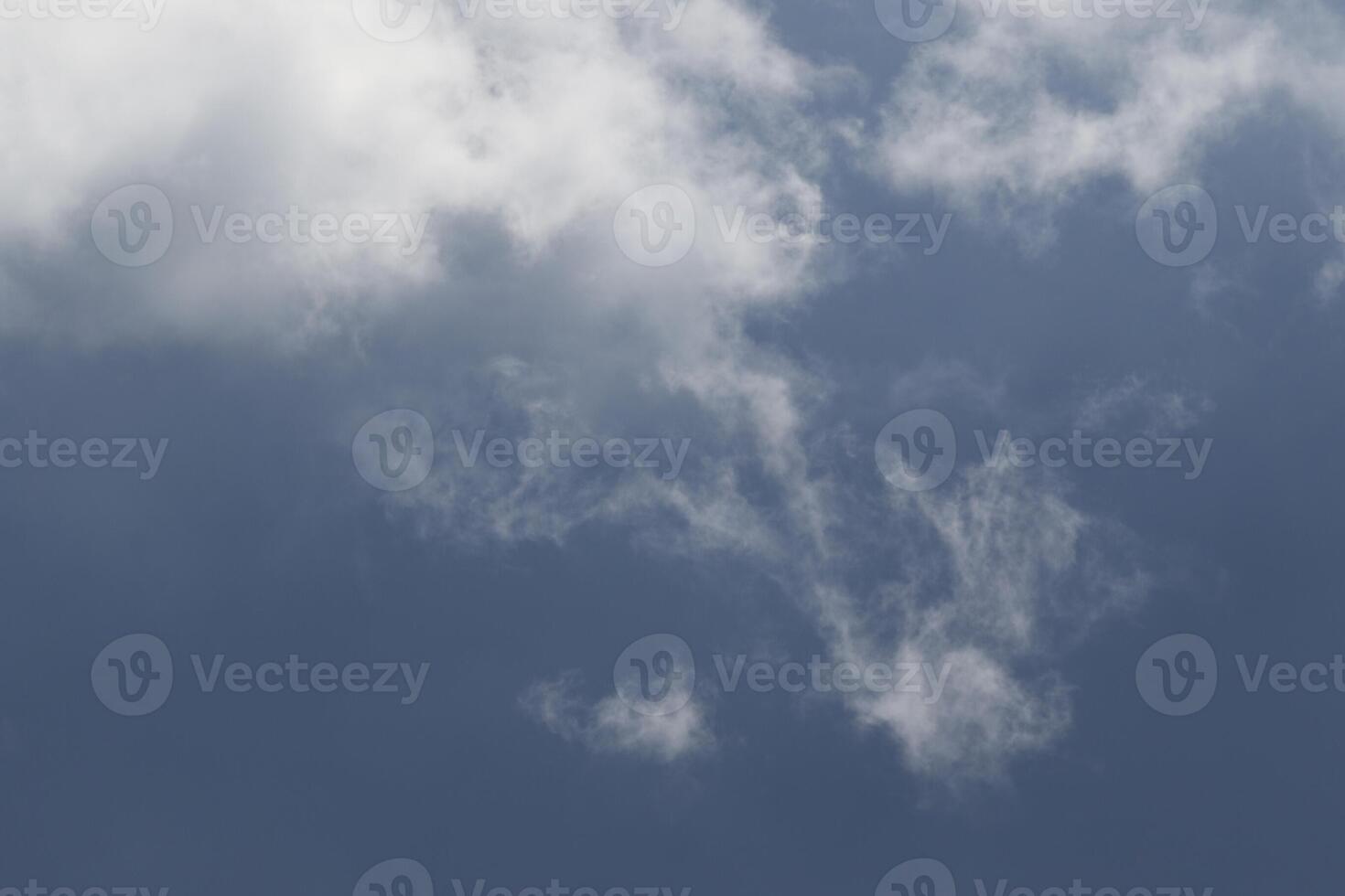 Cloudscape scenery, overcast weather above dark blue sky. Storm clouds floating in a rainy dull day with natural light. White and grey scenic environment background. Nature view. photo