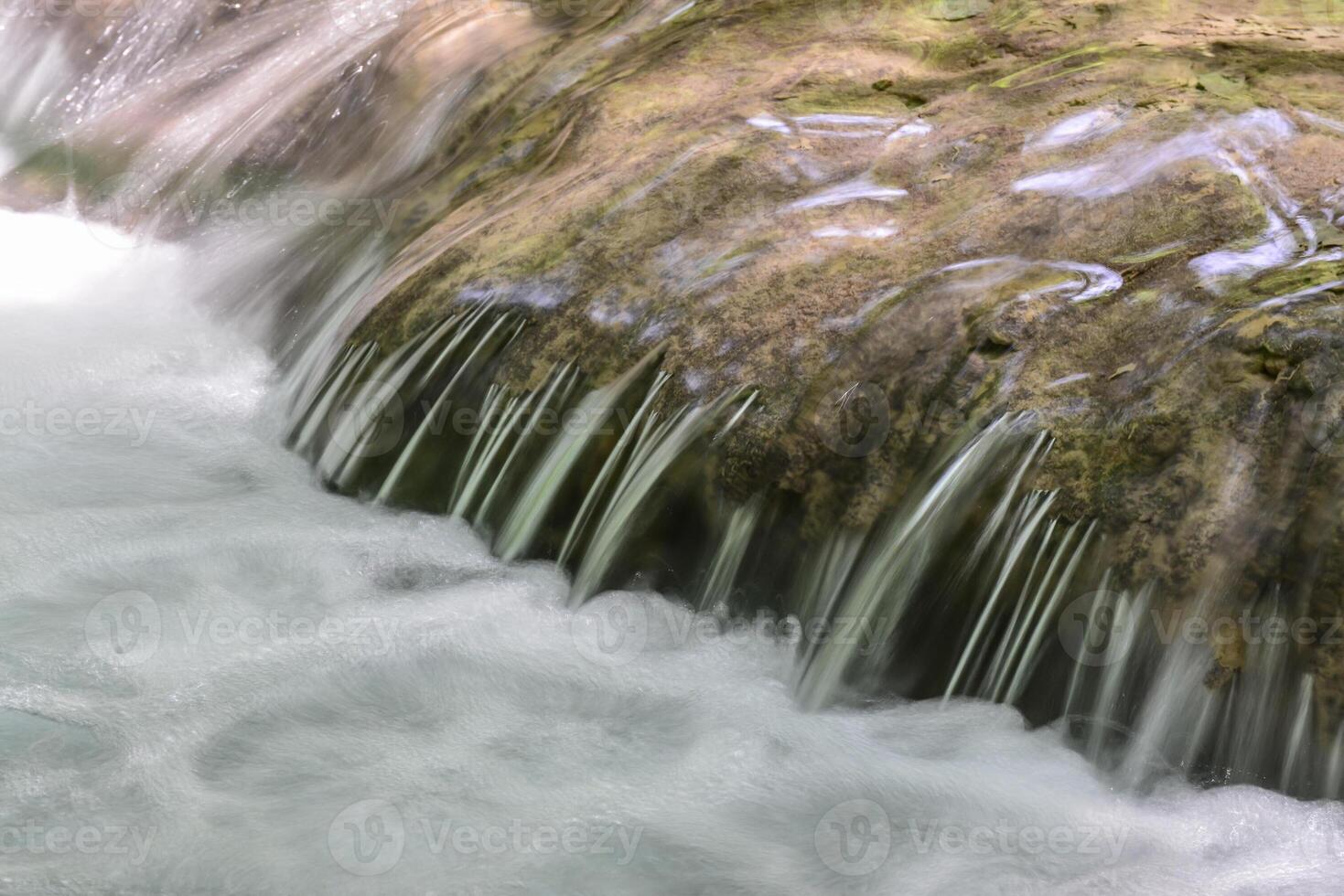 Mountain stream in the forest - long exposure and flowing water photo