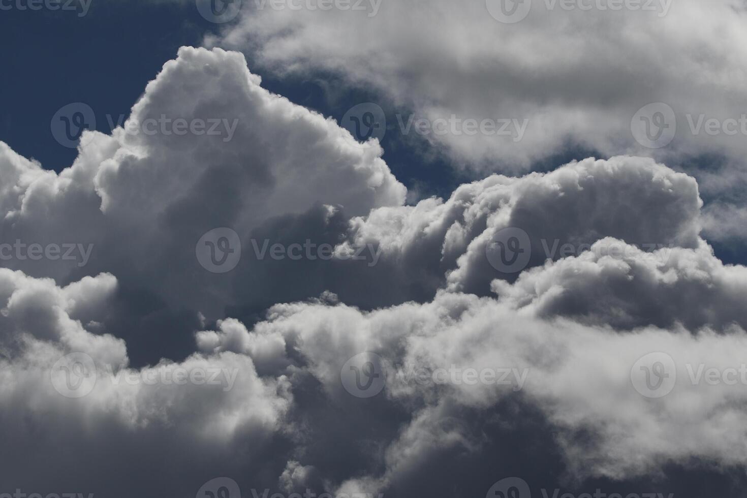 Cloudscape scenery, overcast weather above dark blue sky. Storm clouds floating in a rainy dull day with natural light. White and grey scenic environment background. Nature view. photo