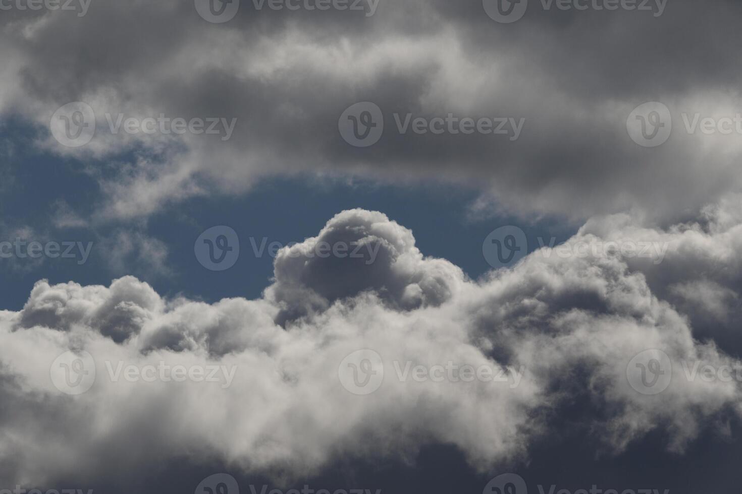 Cloudscape scenery, overcast weather above dark blue sky. Storm clouds floating in a rainy dull day with natural light. White and grey scenic environment background. Nature view. photo