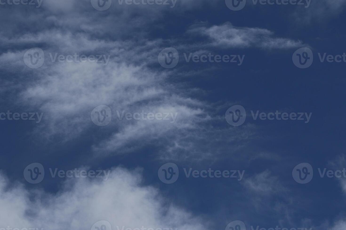 Cloudscape scenery, overcast weather above dark blue sky. Storm clouds floating in a rainy dull day with natural light. White and grey scenic environment background. Nature view. photo
