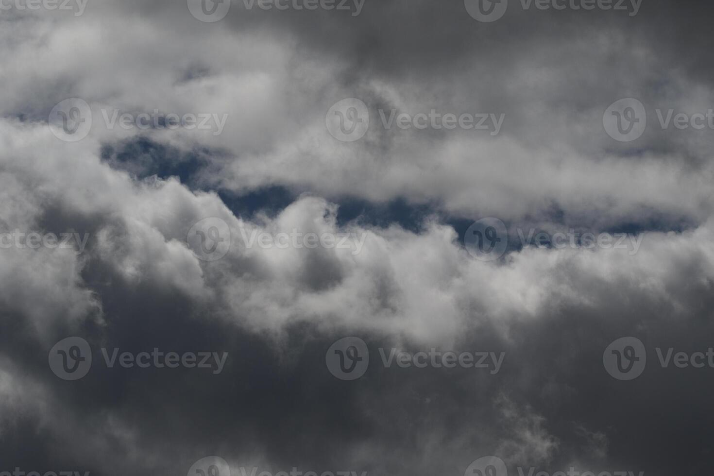 Cloudscape scenery, overcast weather above dark blue sky. Storm clouds floating in a rainy dull day with natural light. White and grey scenic environment background. Nature view. photo