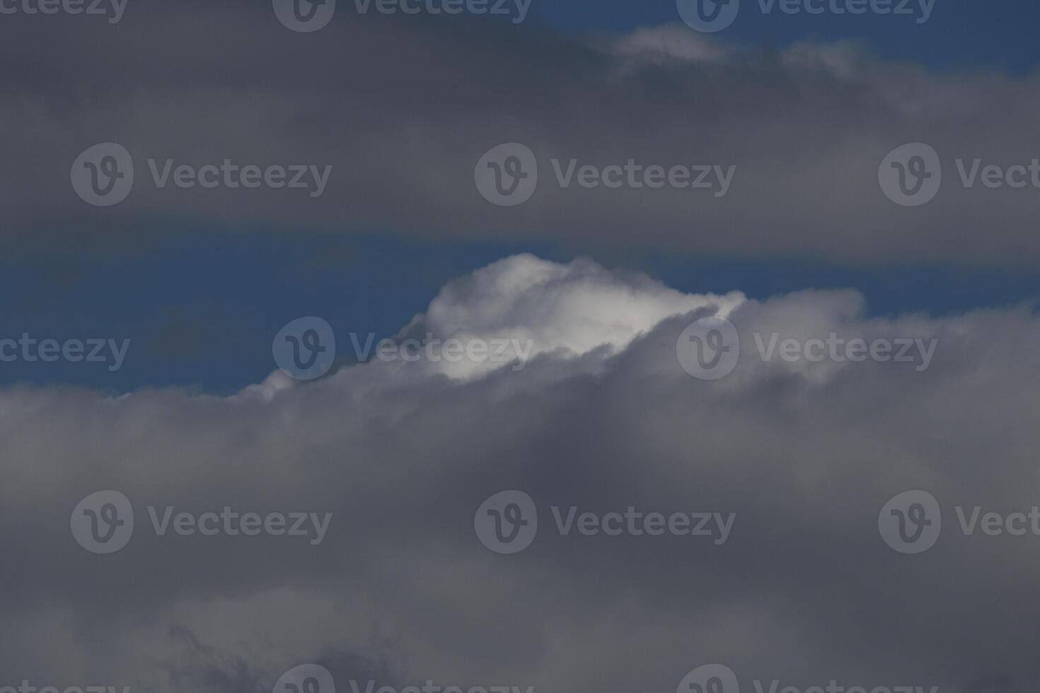 Cloudscape scenery, overcast weather above dark blue sky. Storm clouds floating in a rainy dull day with natural light. White and grey scenic environment background. Nature view. photo