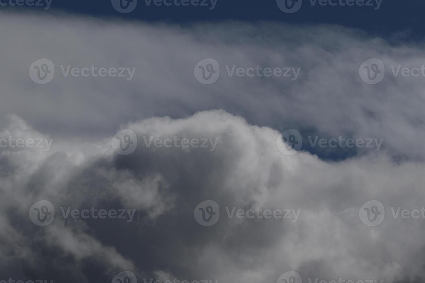 Cloudscape scenery, overcast weather above dark blue sky. Storm clouds floating in a rainy dull day with natural light. White and grey scenic environment background. Nature view. photo