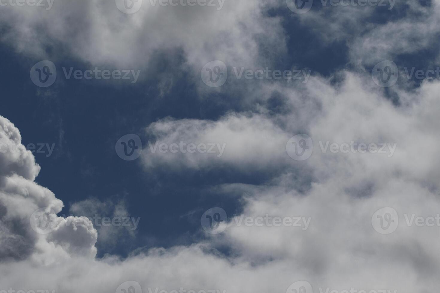 Cloudscape scenery, overcast weather above dark blue sky. Storm clouds floating in a rainy dull day with natural light. White and grey scenic environment background. Nature view. photo