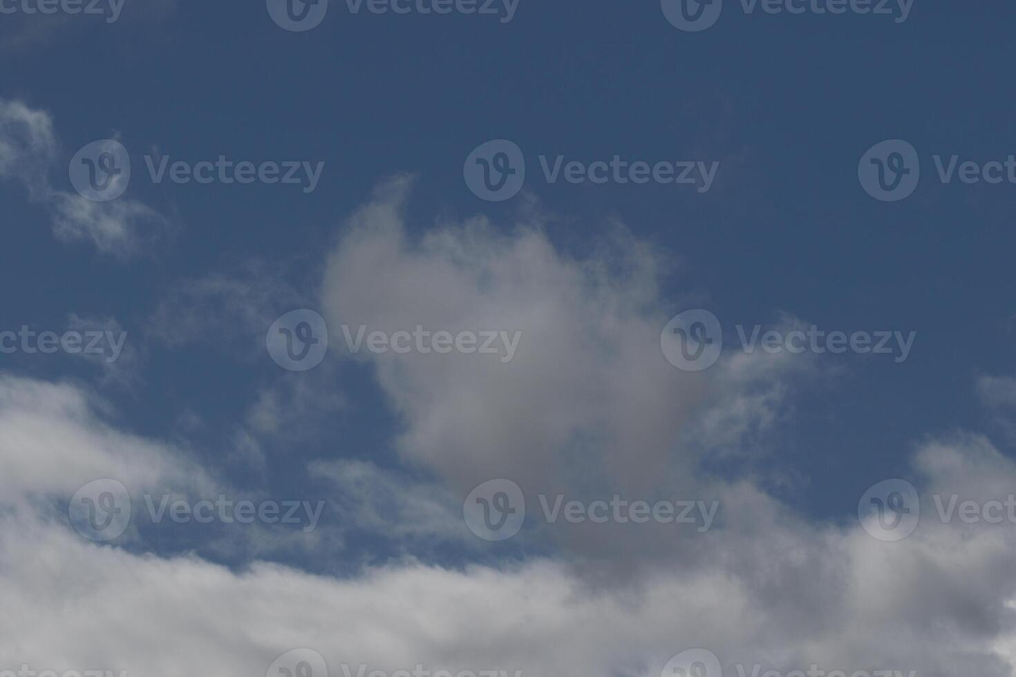 Cloudscape scenery, overcast weather above dark blue sky. Storm clouds floating in a rainy dull day with natural light. White and grey scenic environment background. Nature view. photo