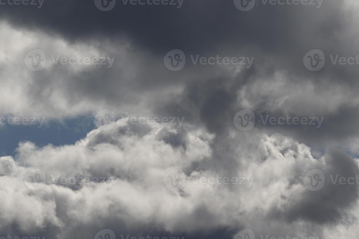 Cloudscape scenery, overcast weather above dark blue sky. Storm clouds floating in a rainy dull day with natural light. White and grey scenic environment background. Nature view. photo