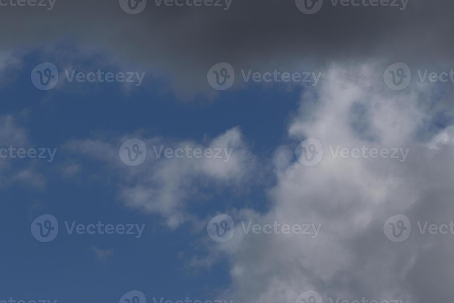Cloudscape scenery, overcast weather above dark blue sky. Storm clouds floating in a rainy dull day with natural light. White and grey scenic environment background. Nature view. photo