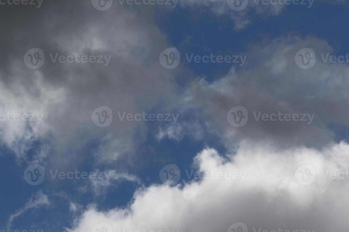 Cloudscape scenery, overcast weather above dark blue sky. Storm clouds floating in a rainy dull day with natural light. White and grey scenic environment background. Nature view. photo