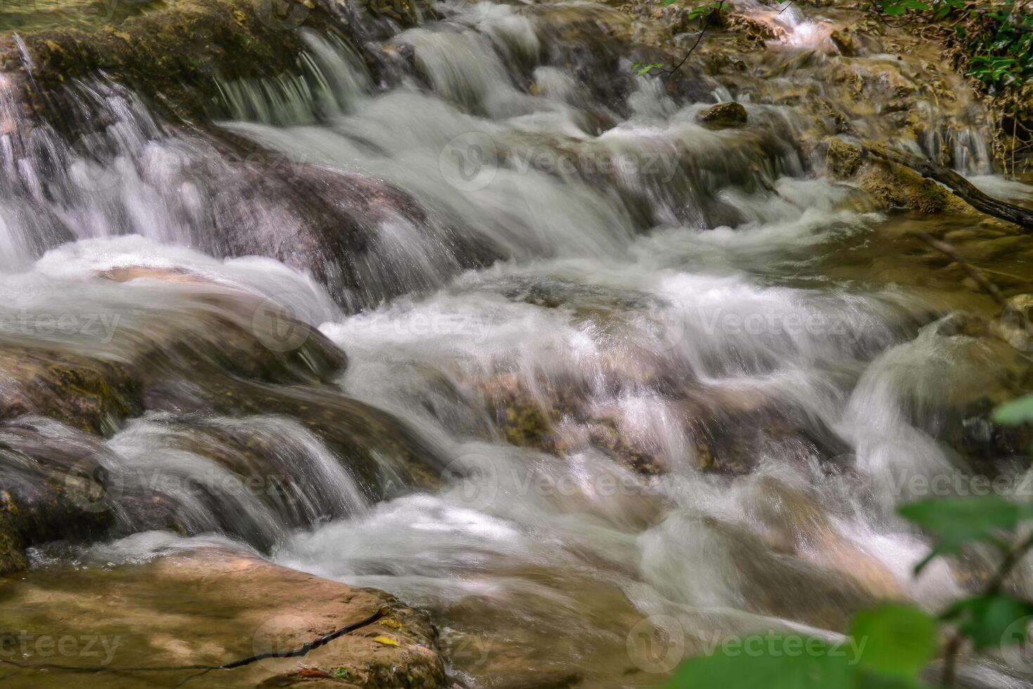 Mountain stream in the forest - long exposure and flowing water photo