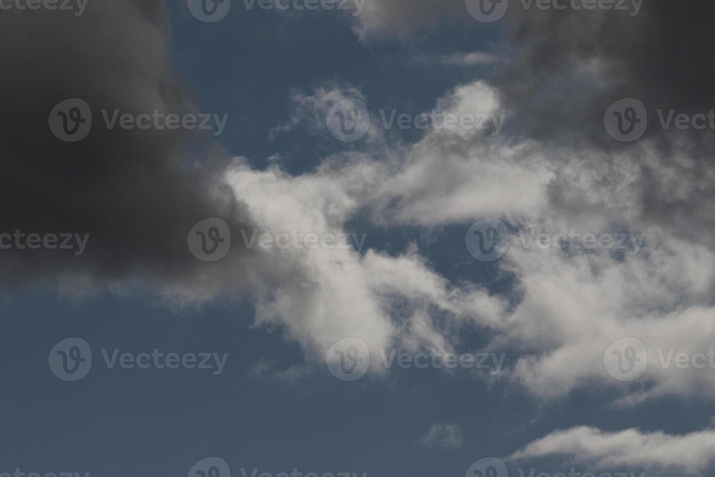 Cloudscape scenery, overcast weather above dark blue sky. Storm clouds floating in a rainy dull day with natural light. White and grey scenic environment background. Nature view. photo