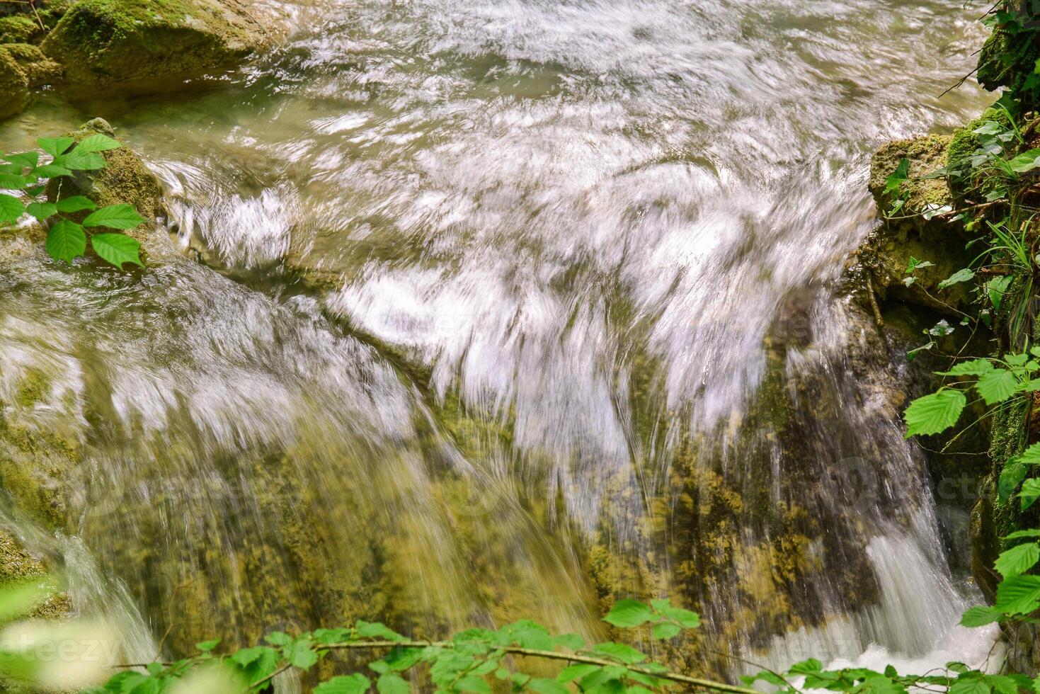 Mountain stream in the forest - long exposure and flowing water photo