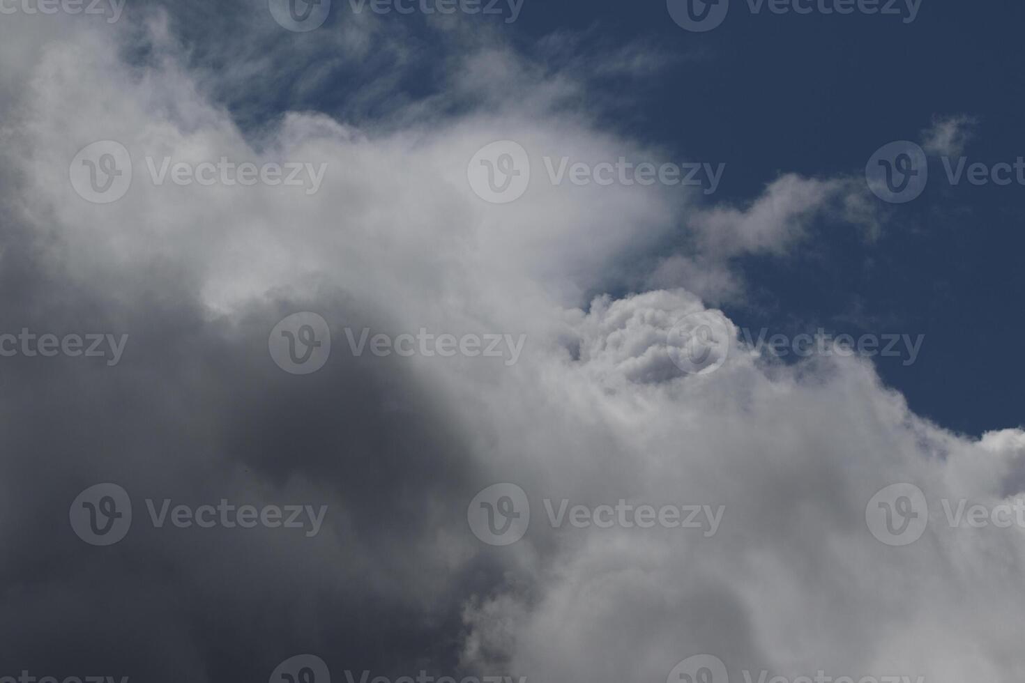 Cloudscape scenery, overcast weather above dark blue sky. Storm clouds floating in a rainy dull day with natural light. White and grey scenic environment background. Nature view. photo