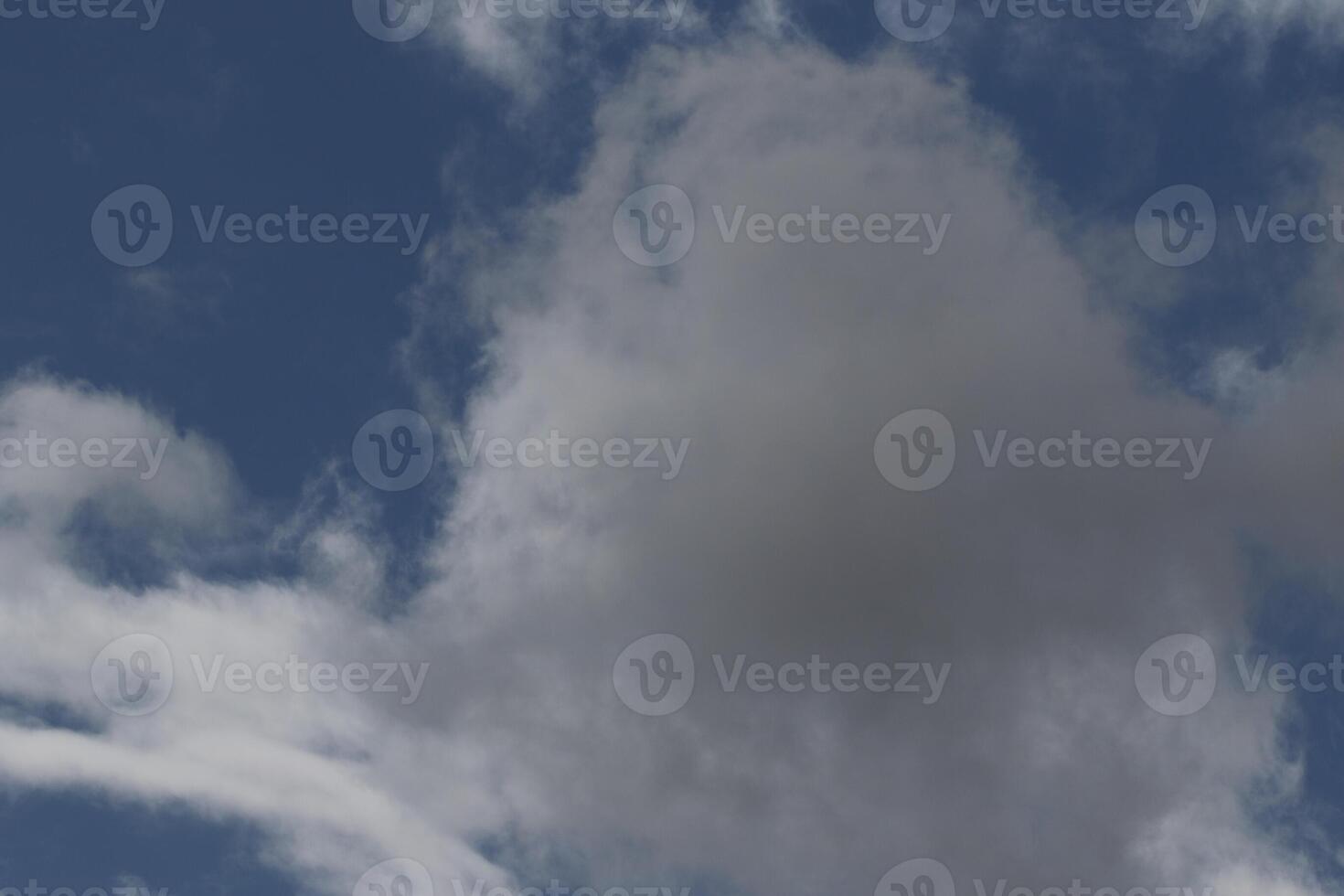 Cloudscape scenery, overcast weather above dark blue sky. Storm clouds floating in a rainy dull day with natural light. White and grey scenic environment background. Nature view. photo