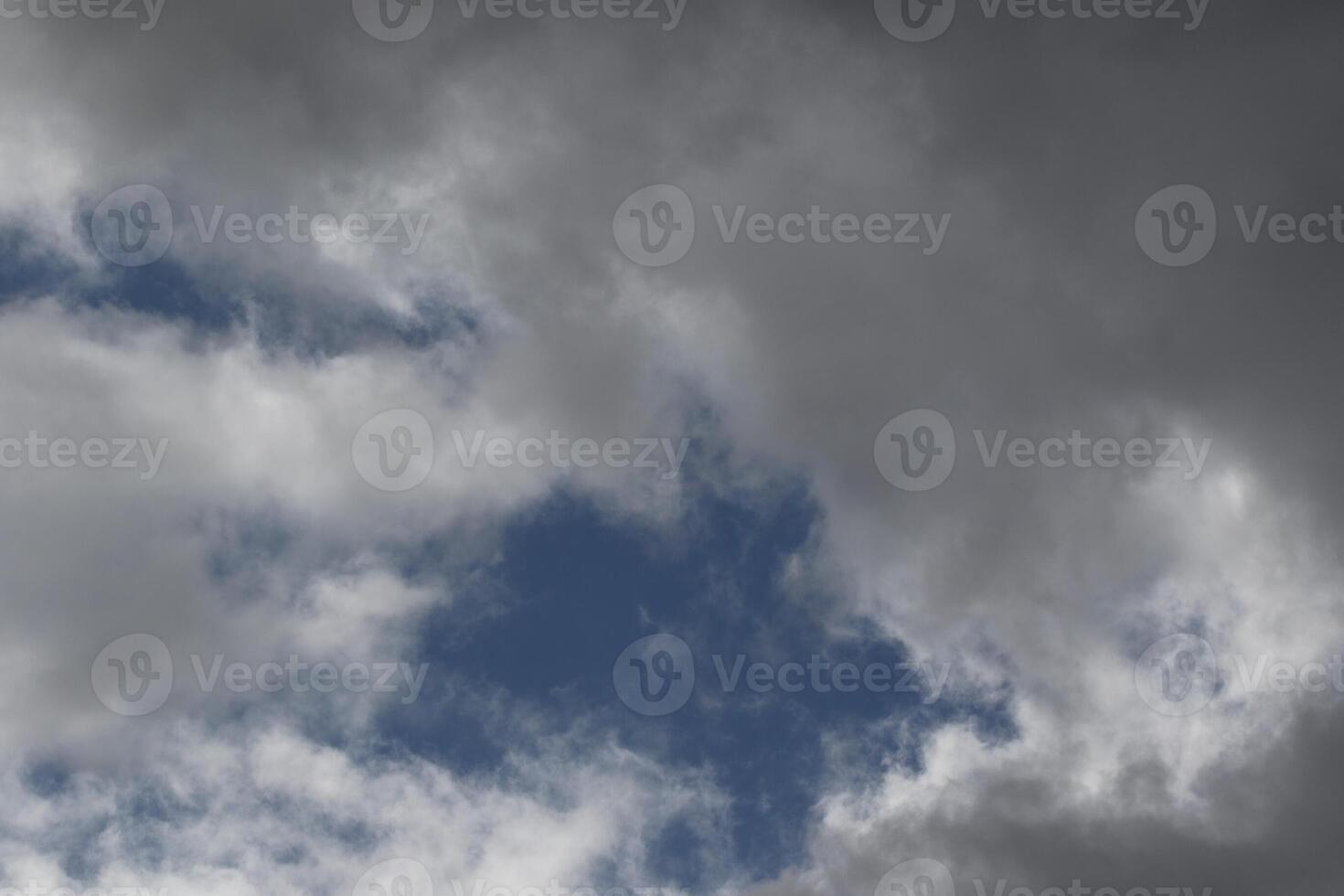 Cloudscape scenery, overcast weather above dark blue sky. Storm clouds floating in a rainy dull day with natural light. White and grey scenic environment background. Nature view. photo