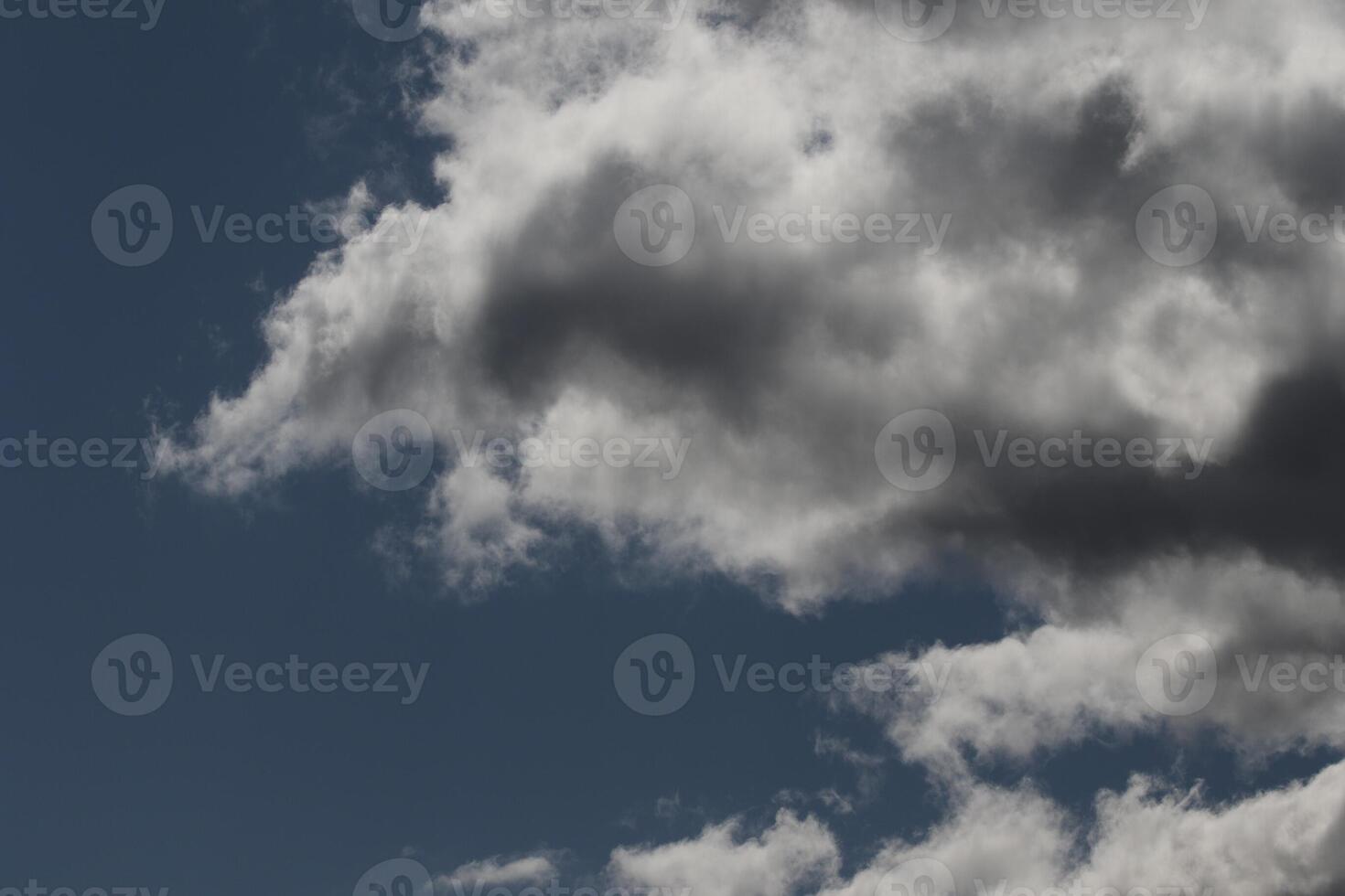 Cloudscape scenery, overcast weather above dark blue sky. Storm clouds floating in a rainy dull day with natural light. White and grey scenic environment background. Nature view. photo