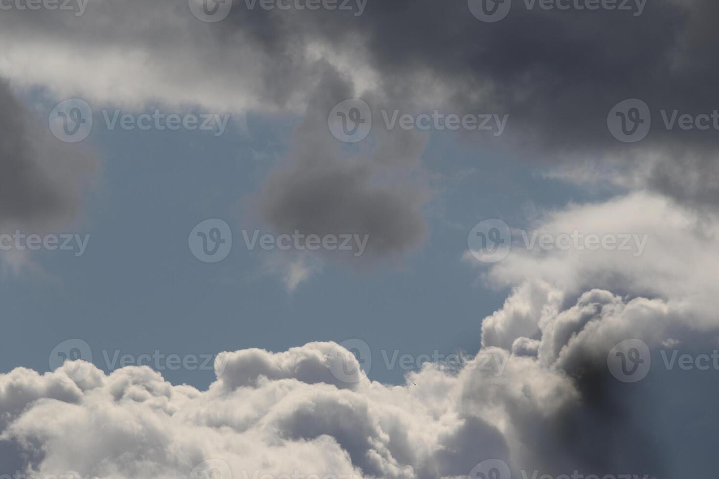 Cloudscape scenery, overcast weather above dark blue sky. Storm clouds floating in a rainy dull day with natural light. White and grey scenic environment background. Nature view. photo