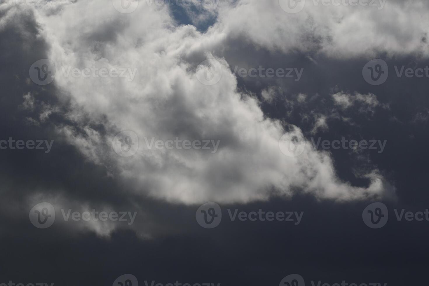 Cloudscape scenery, overcast weather above dark blue sky. Storm clouds floating in a rainy dull day with natural light. White and grey scenic environment background. Nature view. photo