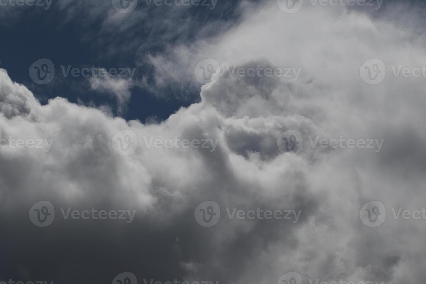 Cloudscape scenery, overcast weather above dark blue sky. Storm clouds floating in a rainy dull day with natural light. White and grey scenic environment background. Nature view. photo