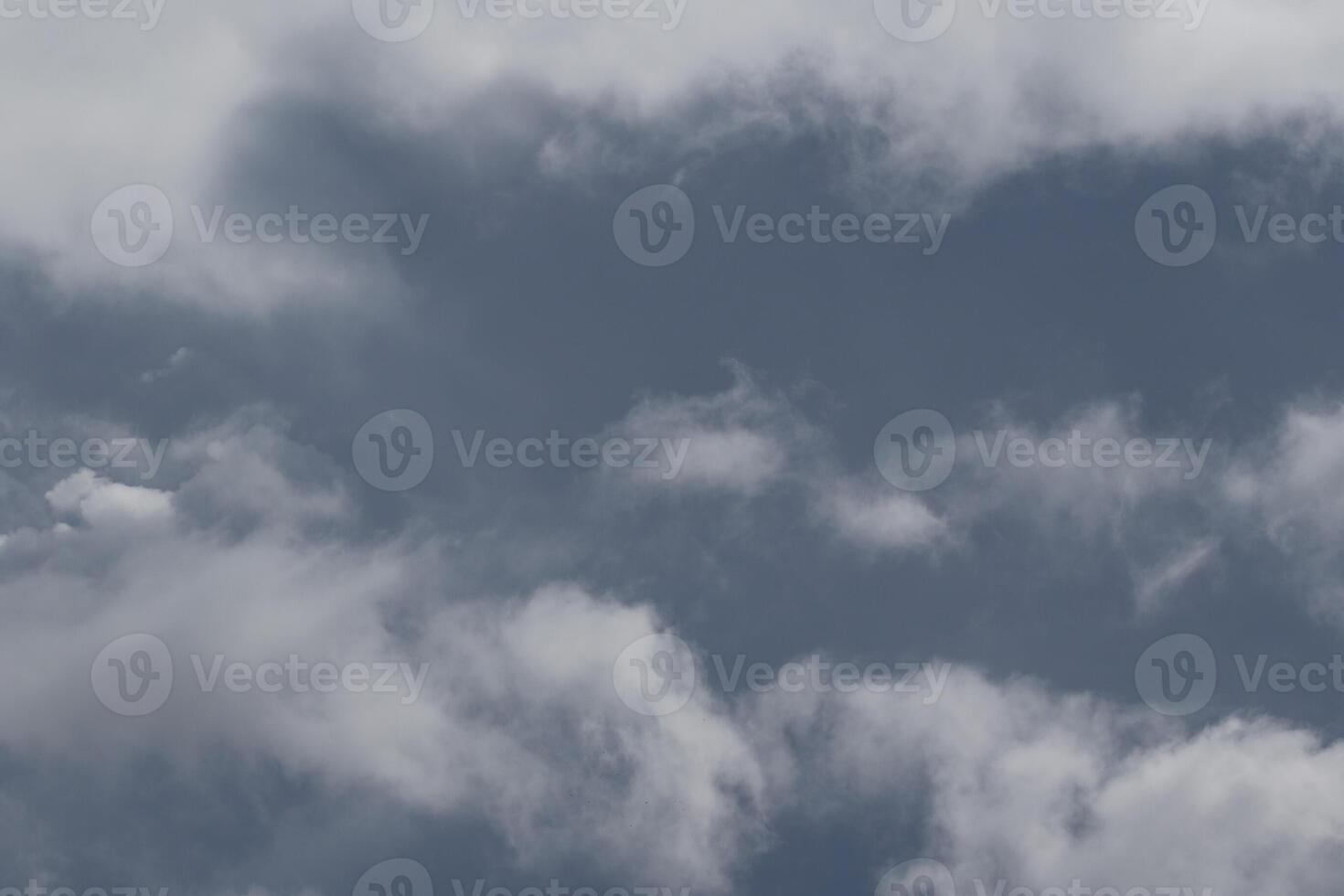 Cloudscape scenery, overcast weather above dark blue sky. Storm clouds floating in a rainy dull day with natural light. White and grey scenic environment background. Nature view. photo