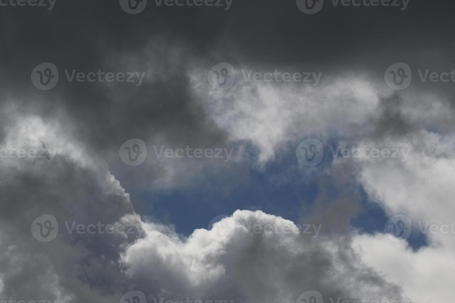 Cloudscape scenery, overcast weather above dark blue sky. Storm clouds floating in a rainy dull day with natural light. White and grey scenic environment background. Nature view. photo