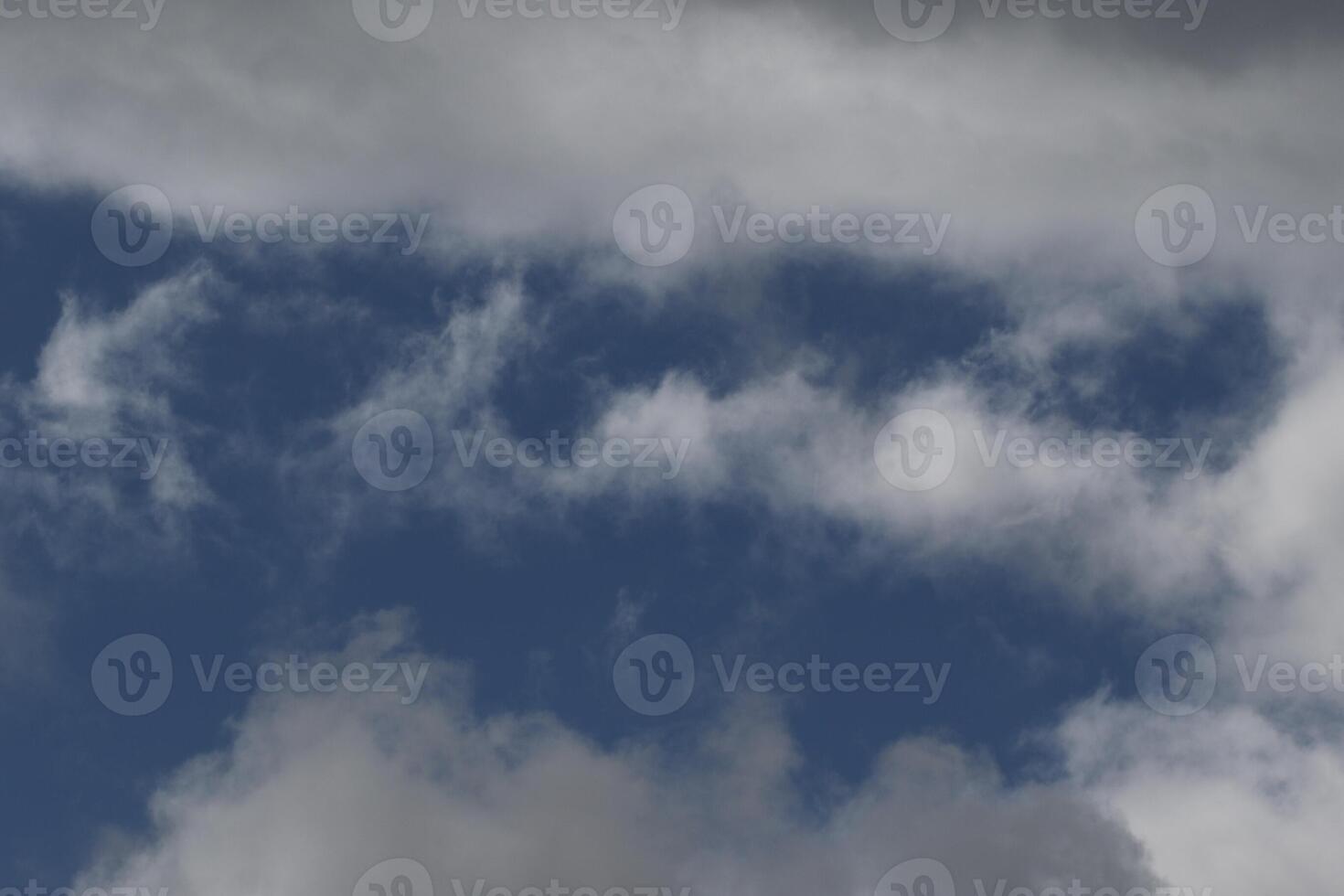 Cloudscape scenery, overcast weather above dark blue sky. Storm clouds floating in a rainy dull day with natural light. White and grey scenic environment background. Nature view. photo