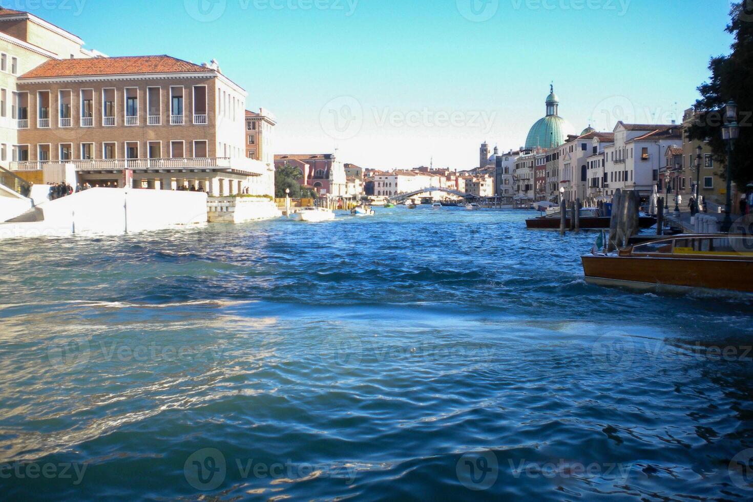 Venice Grand Canal, with its iconic winding waterway flanked by historic buildings and bustling activity, epitomizes the charm and allure of the enchanting city of Venice photo