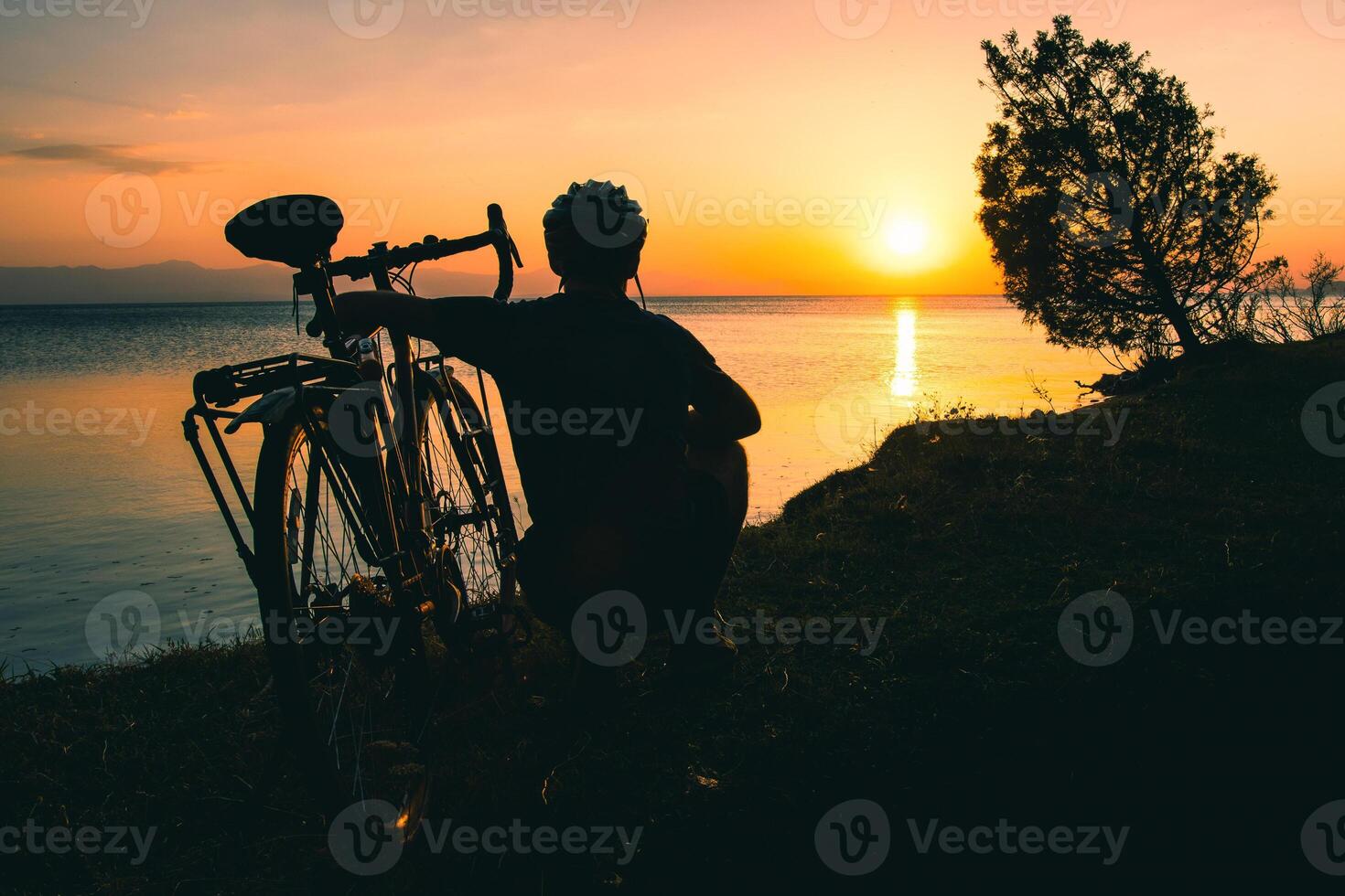 silueta de ciclista viajero con su bicicleta disfrutar puesta de sol ver juntos por tranquilo sevan lago en naturaleza. bicicleta turismo al aire libre en naturaleza foto