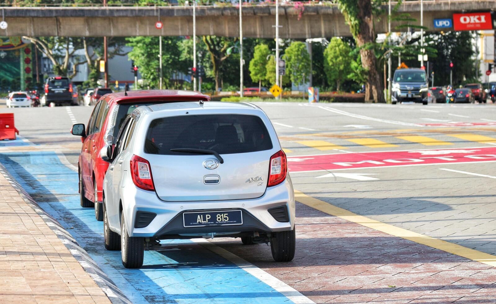 Kuala Lumpur, Malaysia on May 21, 2023. Several cars stop at a red light near the Dataran Merdeka square and Sultan Abdul Samad Building. photo
