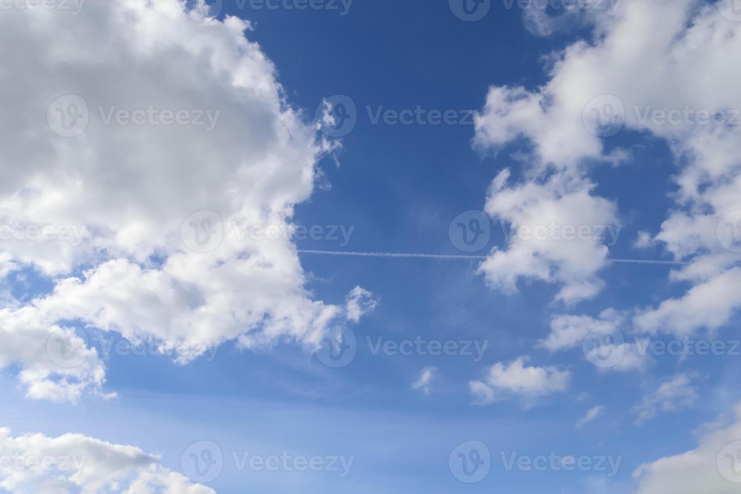 Beautiful fluffy white cloud formations in a deep blue summer sky photo