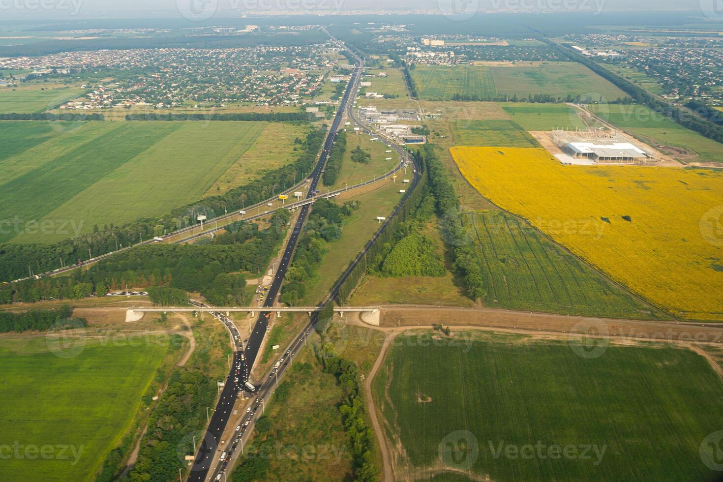 Land view through the airplane window. Fields, roads, rivers from a bird's eye view. Porthole. Look out the window of a flying plane. Top view of the ground photo