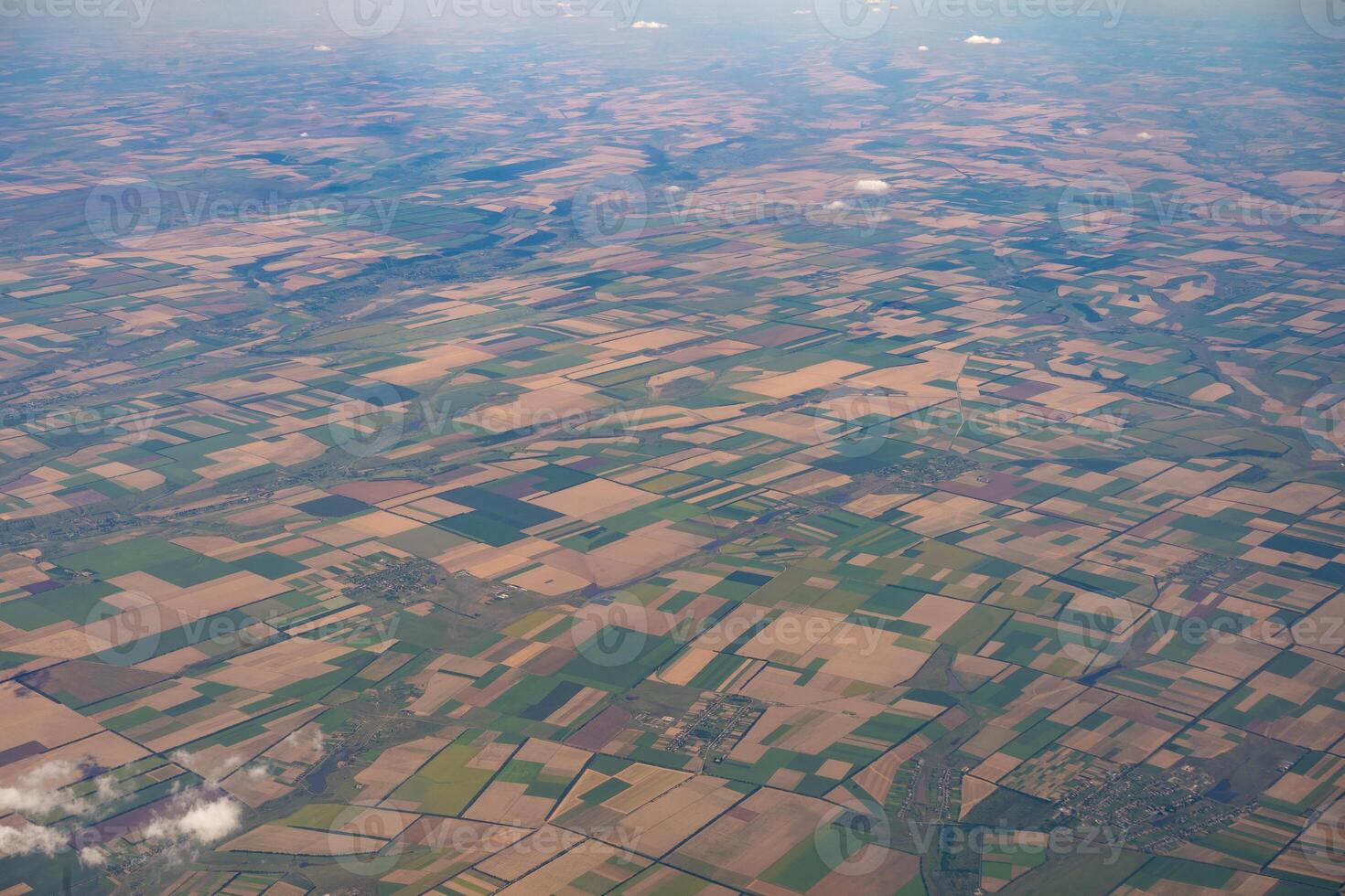 Land view through the airplane window. Fields, roads, rivers from a bird's eye view. Porthole. Look out the window of a flying plane. Top view of the ground photo