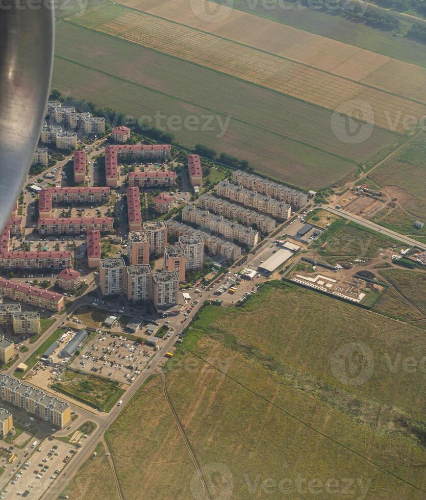 Land view through the airplane window. Fields, roads, rivers from a bird's eye view. Porthole. Look out the window of a flying plane. Top view of the ground photo