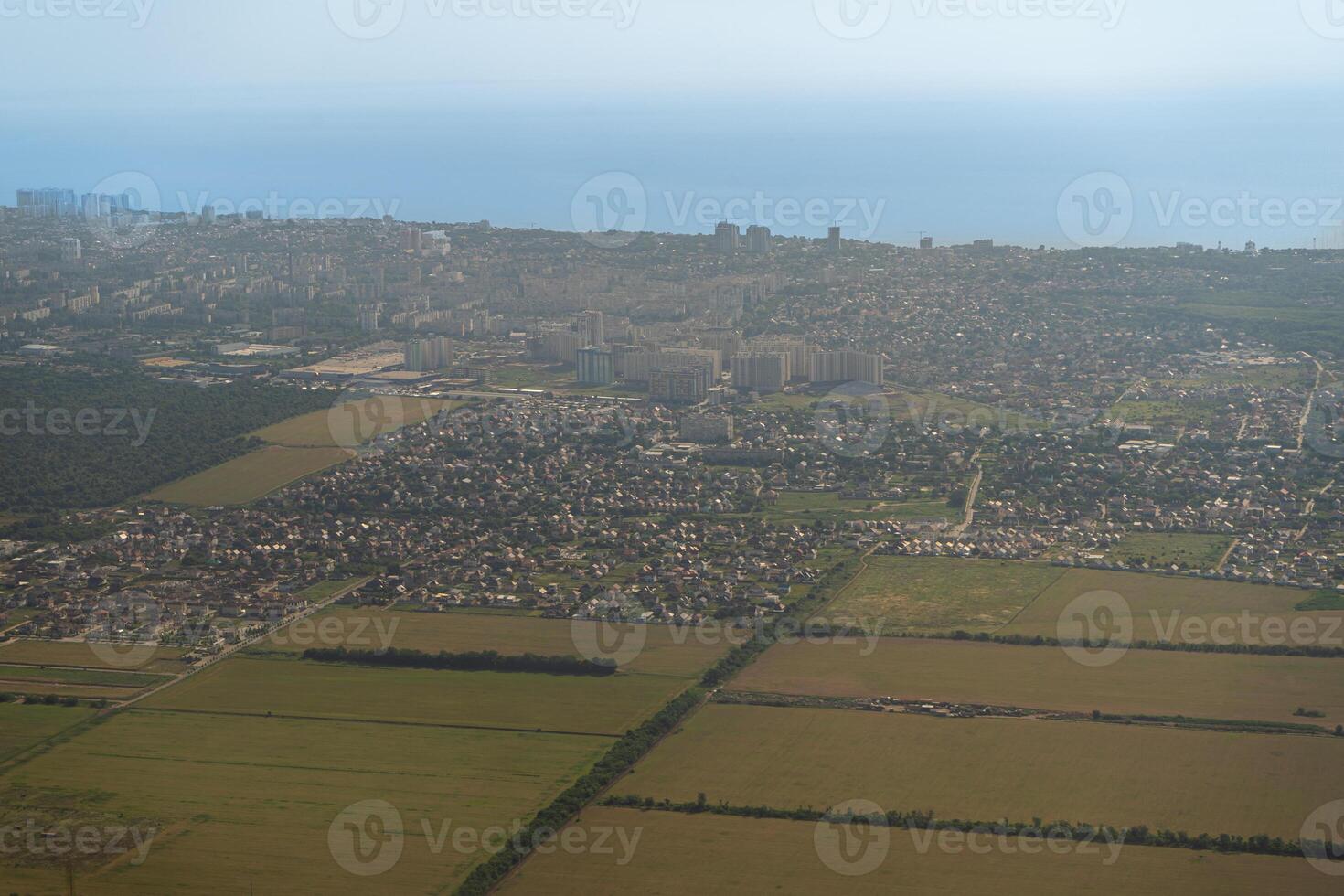 Land view through the airplane window. Fields, roads, rivers from a bird's eye view. Porthole. Look out the window of a flying plane. Top view of the ground photo