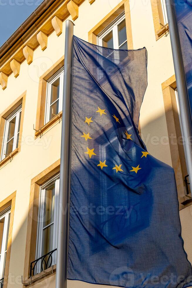 blue european flag with yellow stars is blowing in the wind photo