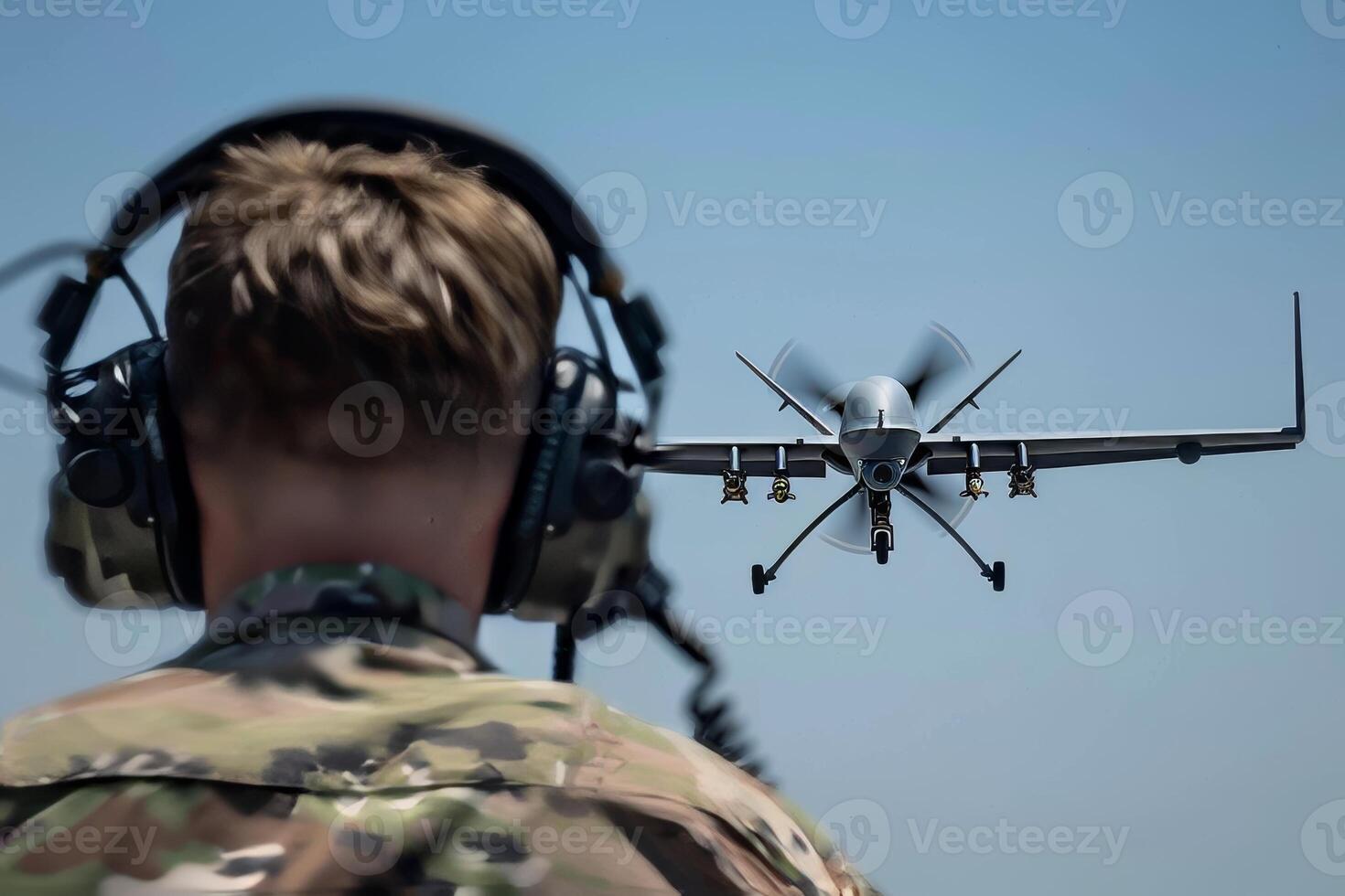 Army soldier in uniform with goggles and headphones closely monitoring a drone aircraft photo