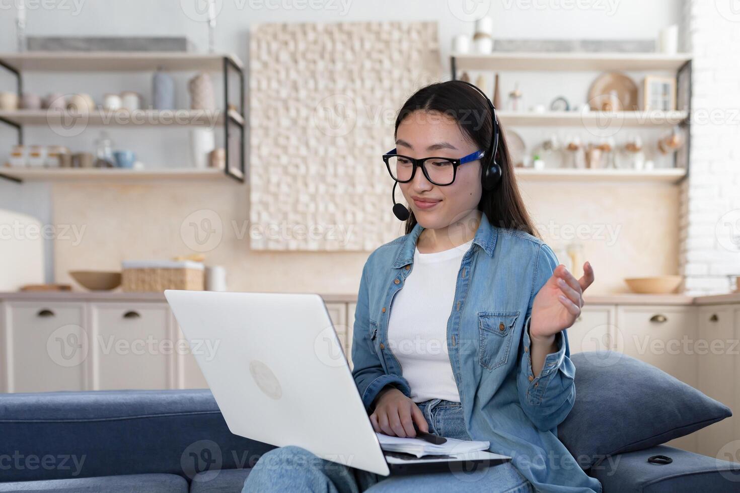 joven hermosa asiático profesor en lentes enseñando estudiantes de forma remota, mujer utilizando auriculares foto