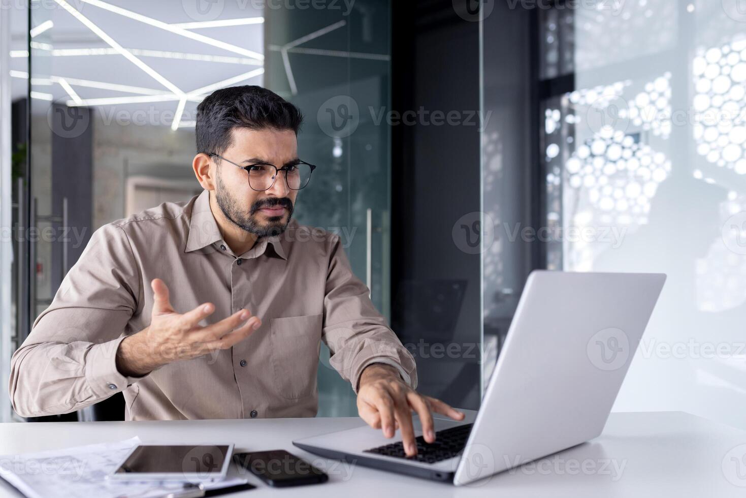 Idle computer, broken laptop at workplace, unhappy angry businessman at workplace shouting unhappy with slow software. photo