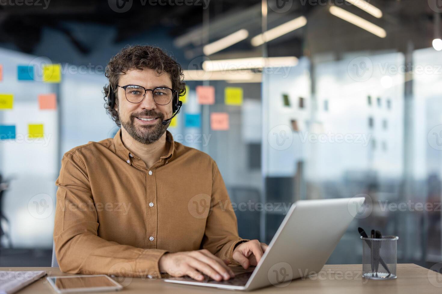 Focused individual participating in a business call using a laptop in a modern office setting. photo