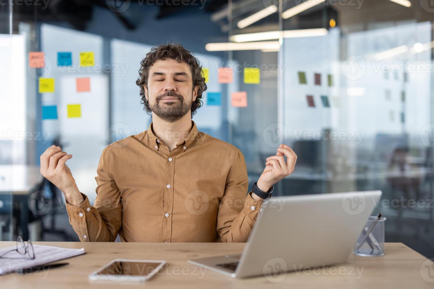 A professional in a serene state practicing meditation at a clutter-free workspace to reduce workplace stress. photo