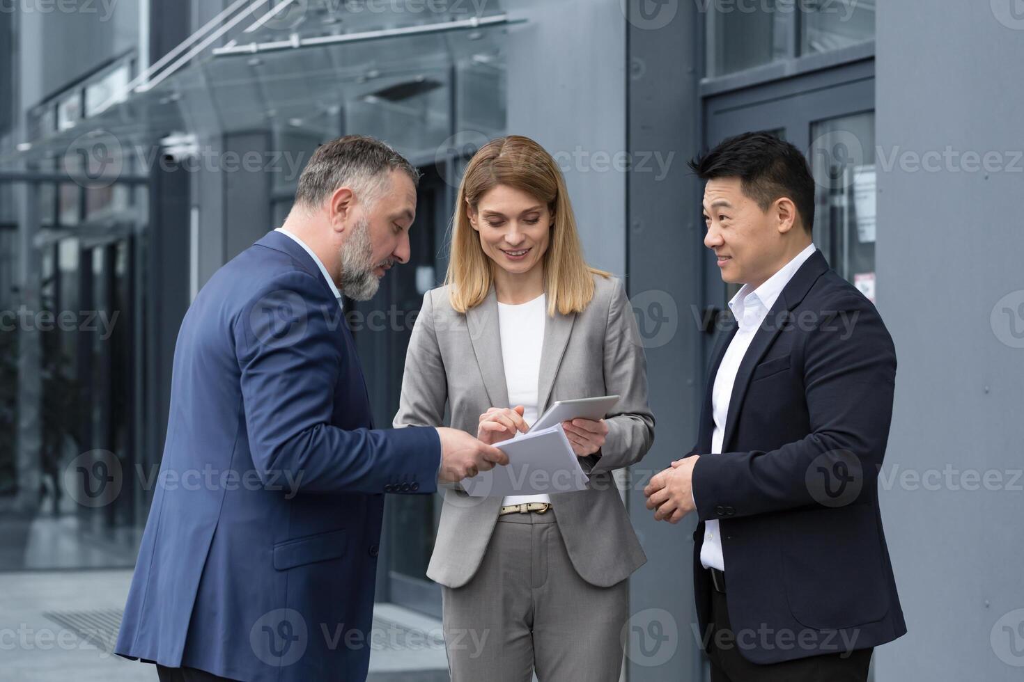 Happy and cheerful diverse business team of analysts engineers programmers discussing new app on tablet, group of business people having fun talking satisfied with work result. photo
