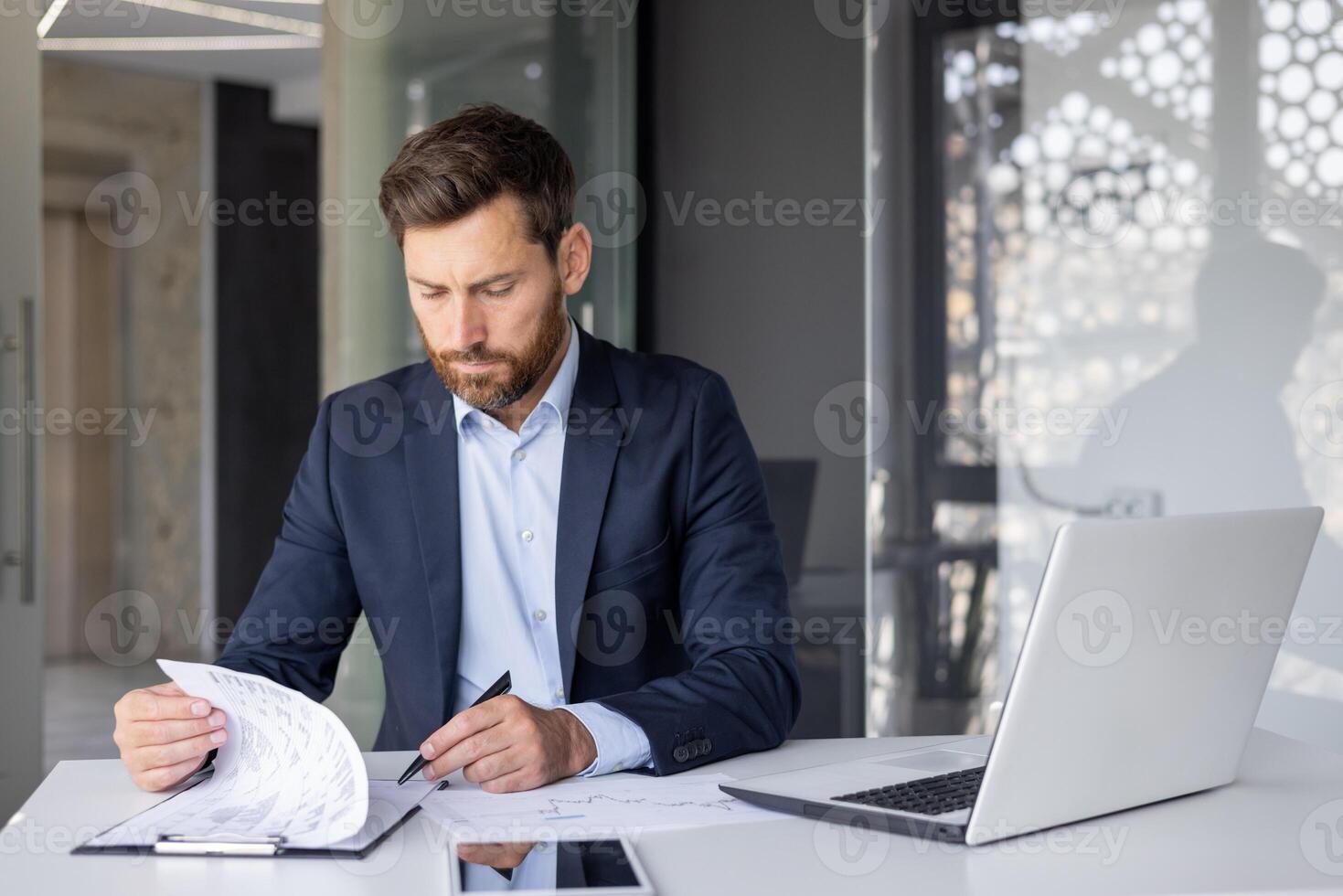 grave joven hombre empresario, empresa propietario y ejecutivo director trabajando a escritorio en oficina con documentos, firma facturas y acuerdo. foto