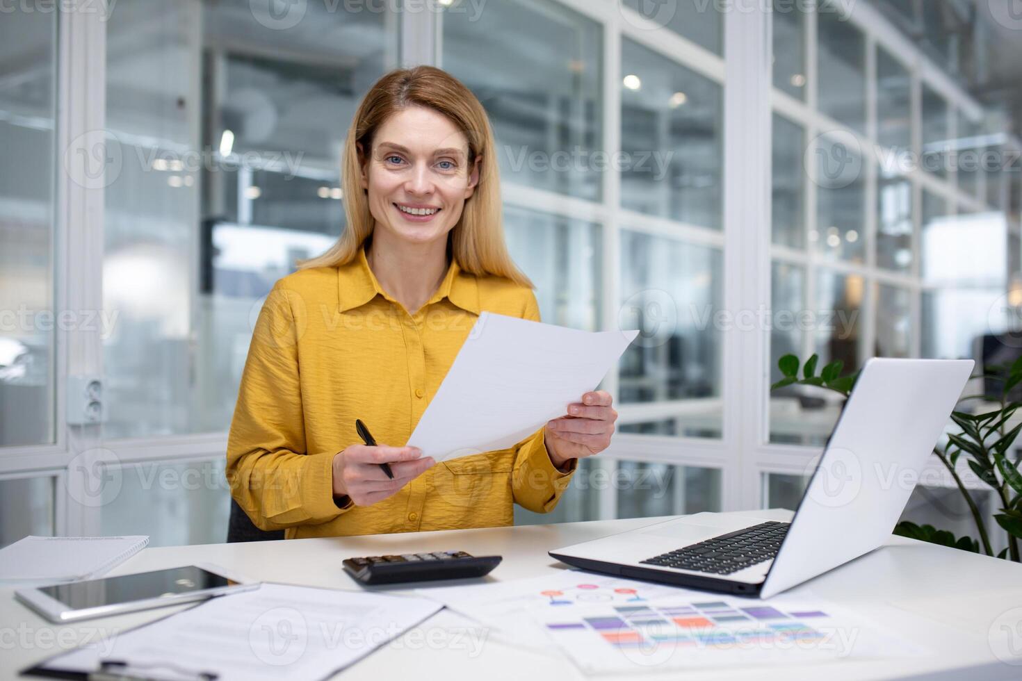 retrato contento exitoso mujer financiero haciendo papeleo, mujer de negocios participación documentos, documentos, contratos y informes en mano, sonriente alegremente, satisfecho trabajando con computadora portátil, utilizando calculadora foto