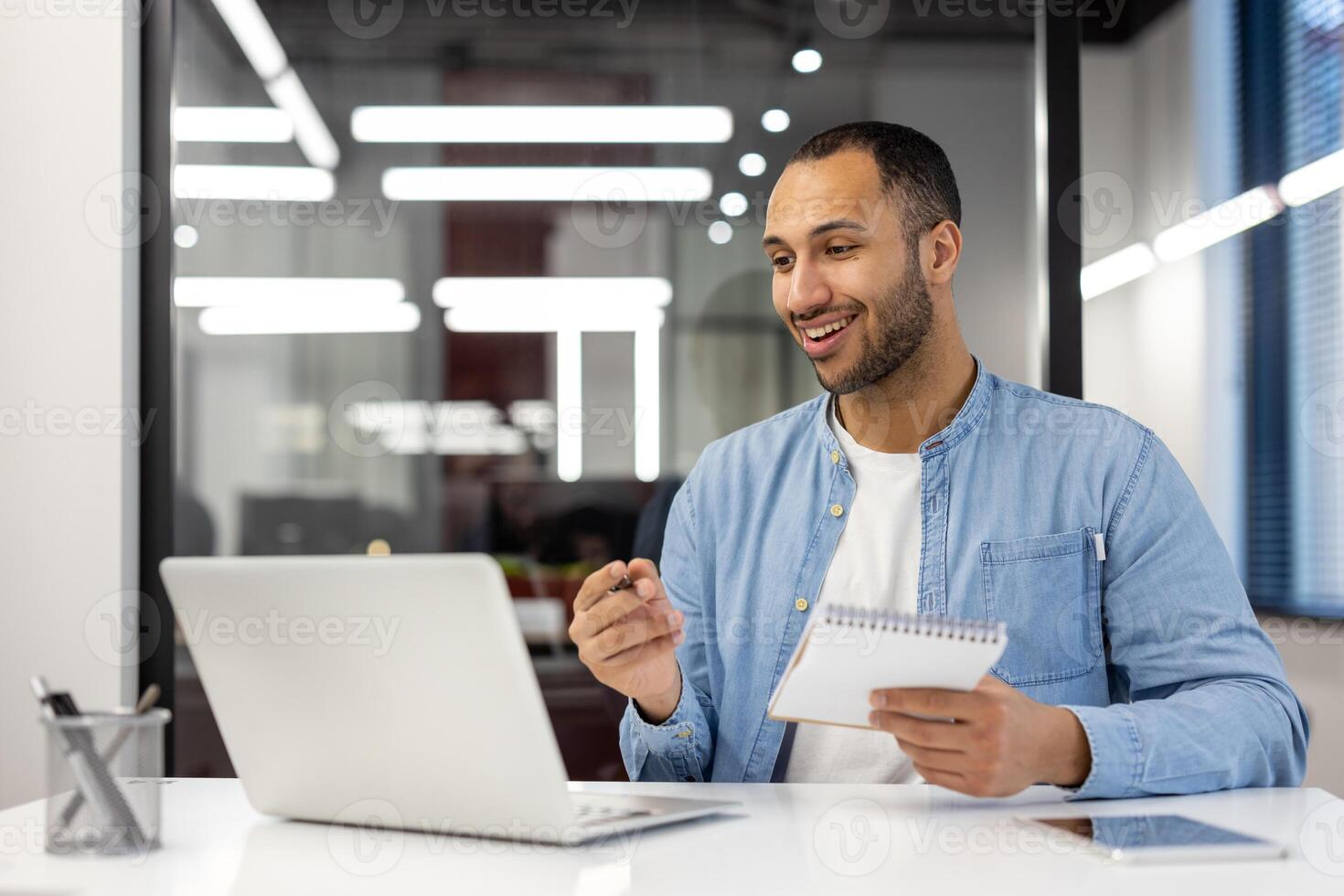 A focused professional man working diligently in a brightly lit modern office. The image captures the essence of productivity and the serious business environment. Perfect for illustrating contemporary workplace concepts. photo