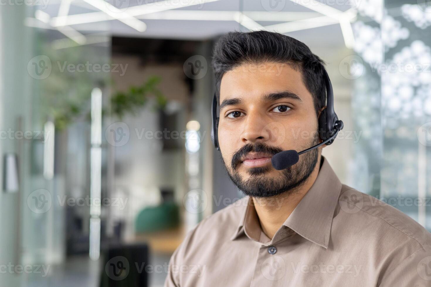 enfocado cliente Servicio representante con auriculares trabajando en un brillante, contemporáneo oficina ambiente. foto