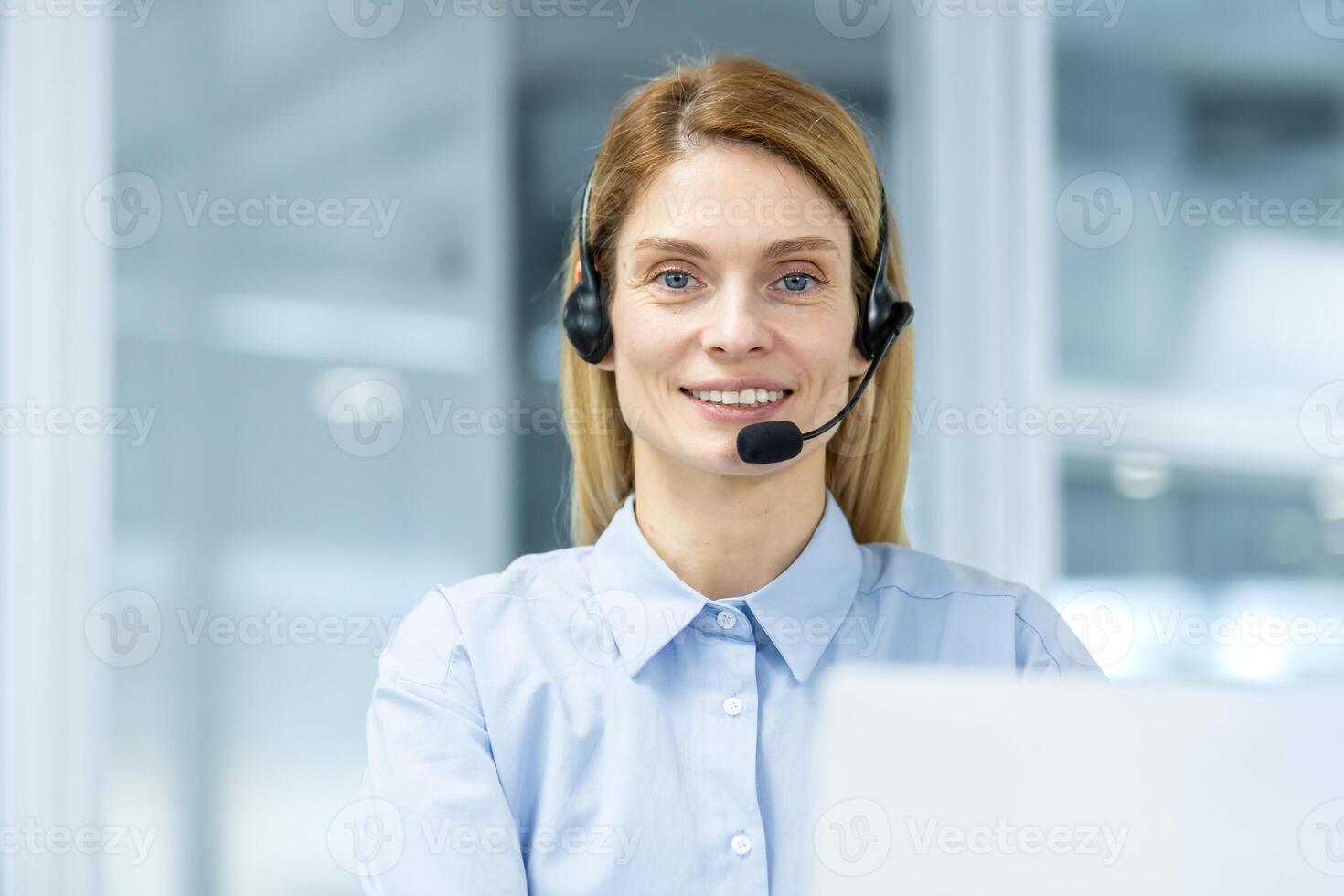 simpático cliente Servicio representante vistiendo un auriculares mirando a el cámara con un confidente sonrisa en un moderno oficina ajuste. foto